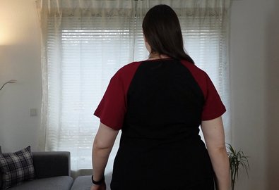 Woman in a black T-shirt with red raglan sleeves, back view